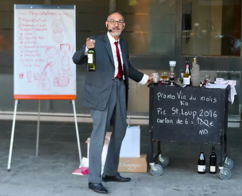 Monsieur Patrick présente une bouteille lors d'une dégustation